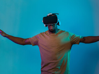 African American man dons VR glasses, engrossed in a virtual reality simulation, gesturing with...