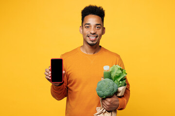 Young fun man wears casual clothes hold mobile cell phone juice green smoothie as detox diet,...