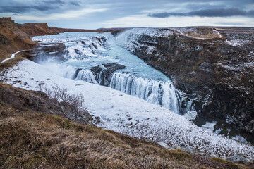 view of the entire Gullfoss waterfall and its surroundings in early winter, at sunset, end of the golden hour, Iceland