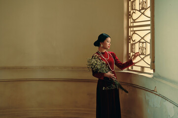 Portrait of young Vietnamese woman in red ao dai dress 