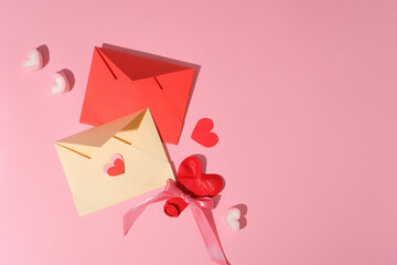 Two handmade envelopes in red and beige color displayed with marshmallow and paper hearts. Vacant space in the right corner for product promotion with Valentine or Women’s Day content