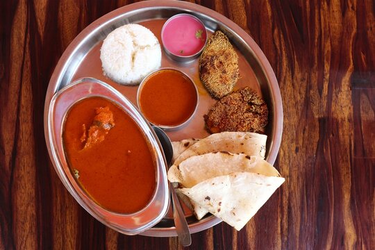 Malvani surmai fish Thali. It is a popular Indian or Konkani food platter that includes king fish or surmai curry, fish rava fry, Rice bhakri, Steamed Rice, Solkadhi, and salad. Copy space.