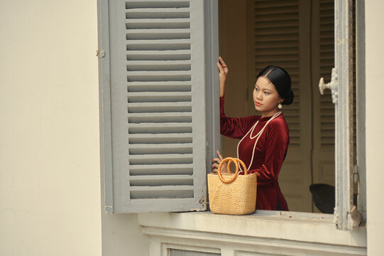 Portrait of young Vietnamese woman in red ao dai dress 