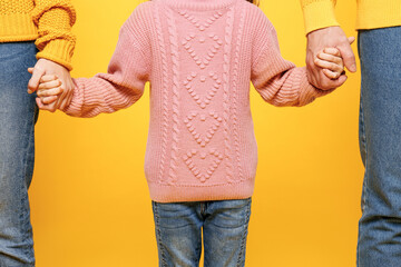 Close up cropped young parents mom dad with child kid girl 7-8 years old wear pink knitted sweater...