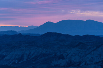 Twilight Hues over Layered Mountain Silhouettes