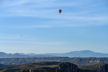 Hot Air Balloon Soaring Over Rugged Canyon Landscape