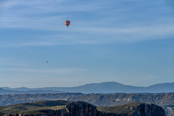 Hot Air Balloon Soaring Over Rugged Canyon Landscape