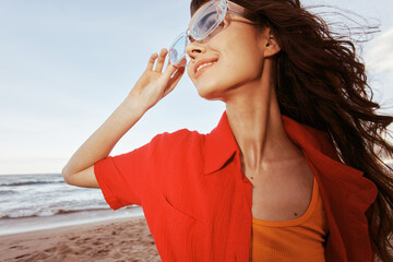 Sheer Joy: Smiling Woman Embracing Freedom in Colorful Sunglasses, Happiness at Sunset on Sandy...