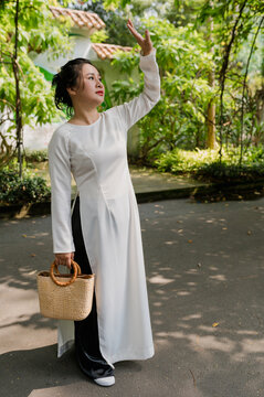 Portrait of Vietnamese woman wearing national dress ao dai in the park