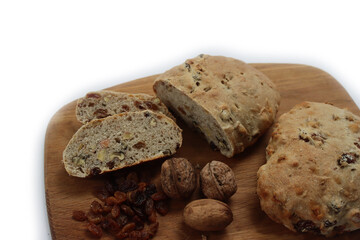 Homemade sliced Pan co' Santi from Tuscany (Italy) on wooden cutting board on white. Traditional sweet bread with raisins, almonds, walnuts and aniseed and Vinsanto