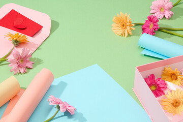 Presents adorned with wrap, ribbons, cards, fresh flowers, and a box on a pastel green backdrop, embodying the charm of homemade gifts in a delightful close-up scene.