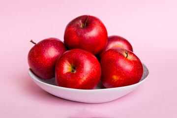 juicy red apples in a bowl or plate on the table top view. Copy space
