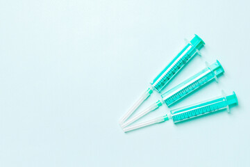 Top view of syringes in a row for medical injection on colorful background with copy space. Health and vaccination concept