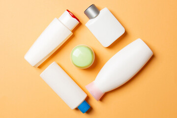 Set of White Cosmetic containers isolated on colored background, top view with copy space. Group of plastic bodycare bottle containers with empty space for you design