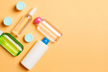 Cosmetics SPA branding mock-up, top view with copy space. set of tubes and jars of cream flat lay on colored background