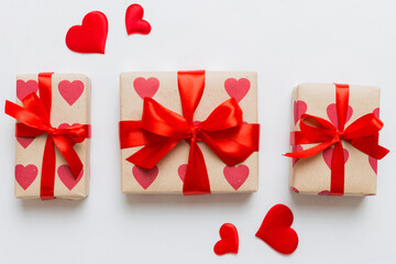 Top view photo of valentine day decorations gift box with red ribbon bow on colored background. Holiday gift boxes with top view