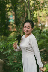 Obraz premium Beautiful Vietnamese woman in ao dai dress outdoor