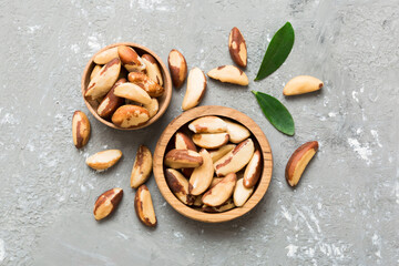 Fresh healthy Brazil nuts in bowl on colored table background. Top view Healthy eating bertholletia concept. Super foods