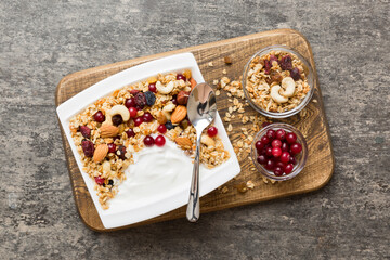 Healthy breakfast food with granola, yogurt, fruits and nuts. Dessert parfait with dried fruits for breakfast