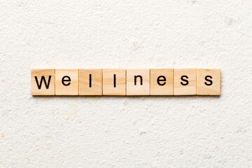 Wellness word written on wood block. Wellness text on cement table for your desing, concept