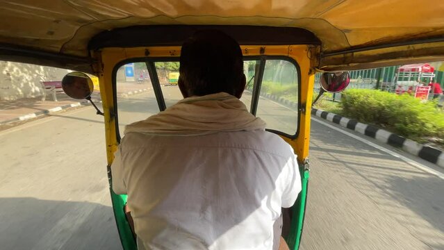 Unrecognizable man Driving an Auto Rikshaw on the streets of India