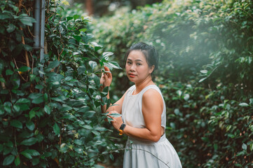Portrait of Asian Woman in a white dress near the lake in the forest