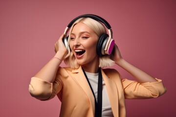 Fototapeta premium A blonde girl with an expressive face listening music with headphones