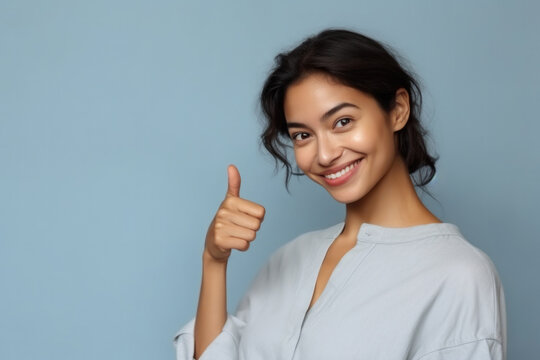 Young smiling woman showing a thumbs up gesture