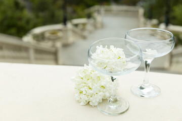 Two glass glasses with flowers on the background of the sea.