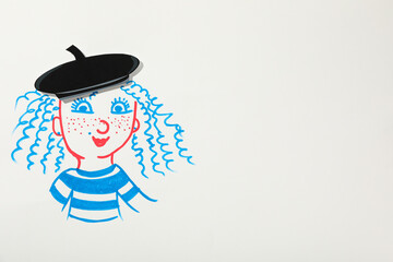 A French girl is drawn on a piece of paper with a beret on her head.