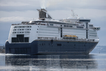 Color passenger freighter roll on roll off ro-ro pax cruise ferry Fantasy Magic in port of Oslo, Norway with city skyline, yachts, marine vessels and harbor infrastructure