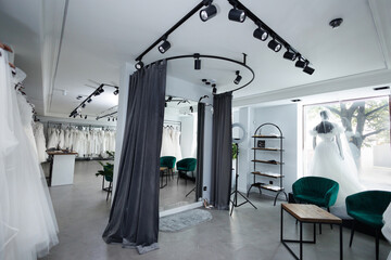 Wedding salon with a large selection of dresses and a fitting room.
