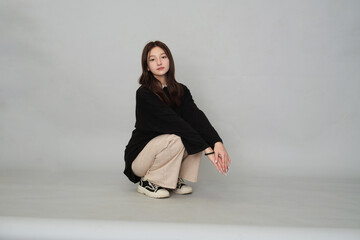 A 13-year-old girl, looking wistful in a chic sweater, embodies the quiet introspection and...