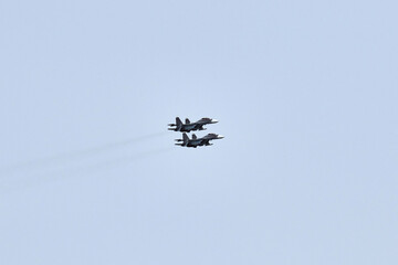 Two Russian military fighter planes armed with missiles flies in blue sky, airborne mission of fighters with targeting system performs an aerial maneuvers for military operation, russian aviation