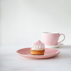 cupcake with cup of coffee on white table