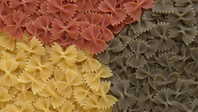 Italian tricolore farfalle pasta background with separated colours.  Seamless loop. 