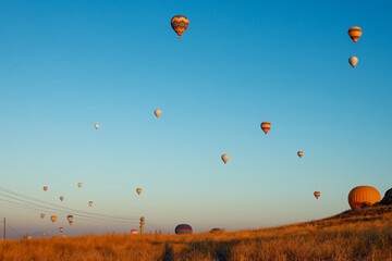 Hot air balloons flying against the blue cloudless sky