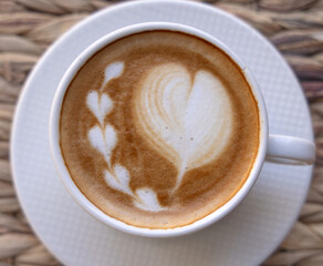 tasty delicious croissants and coffee cappuccino cup with hearts from milk foam in cafe, french pastry.woman hand girl dipping croissant in cup.good morning concept, cozy warm photo