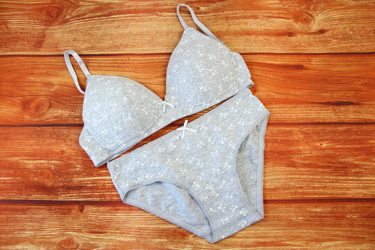 Cotton gray panties and bra on wooden background