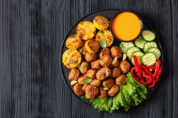 baked meatballs with vegetables and sauce on plate