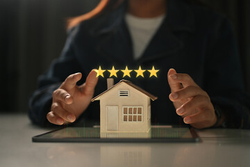 Businesswoman showing 5 stars rating with home model. Real estate appraisal concept and excellent...