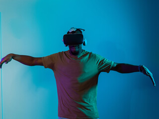 African American man dons VR glasses, engrossed in a virtual reality simulation, gesturing with...
