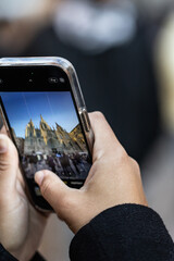 Hands of unrecognizable person taking a cell phone picture of the Barcelona Cathedral in Spain