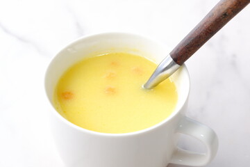 熱々のコーンクリームスープをスプーンでかきまぜる
