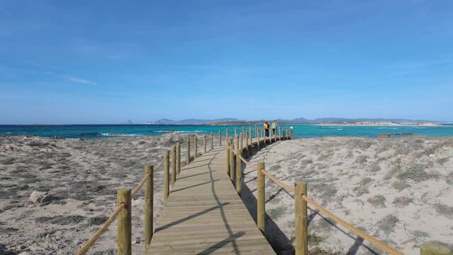 Walking on a Wooden Boardwalk Over Sand Dunes by the Sea