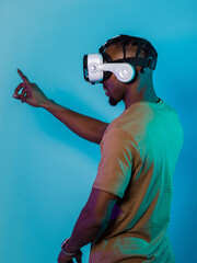 Immersed in a digital realm, an African American man navigates the virtual landscape with a VR...