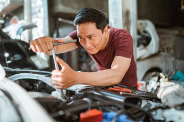 car mechanic using T socket to car engines parts for fixing