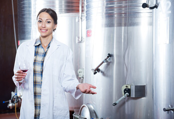 Professional woman checks the wine at factory