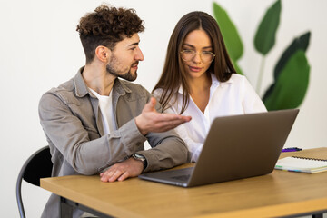 Fototapeta premium Businessman and businesswoman working with laptop at office
