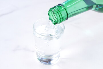 韓国の焼酎（ソジュ）をグラスに注ぐ
